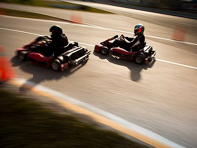 Two go karts racing on an outdoor circuit