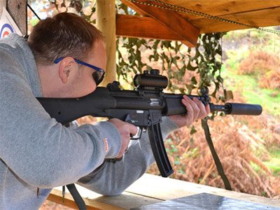 A man firing a rifle at a target 