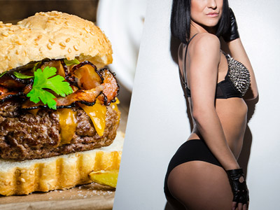 A naked woman eating a sandwich