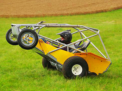 A man in a yellow rage buggy on a field