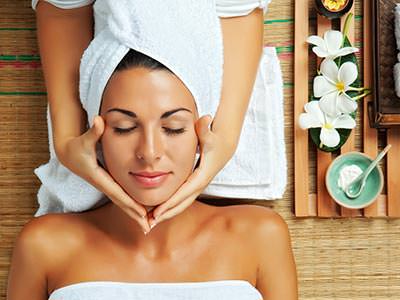 woman receiving a facial, realxing with a towel on her head