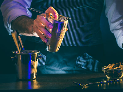 Someone at a bar making a cocktail at a workshop in Prague