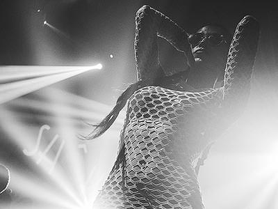Black and white image of a woman in a fishnet top 