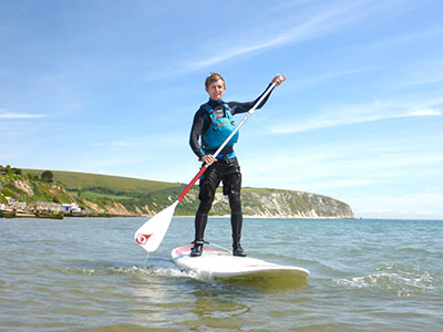 A person standing on a paddle board holding an oar