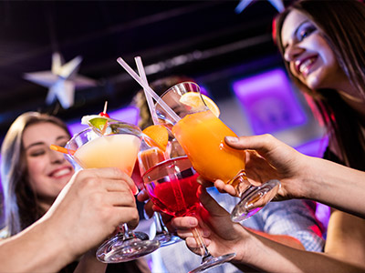 Two pink cocktails being poured from a cocktail shaker