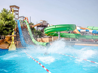 A woman in a black bikini, sat in a yellow dinghy in a pool