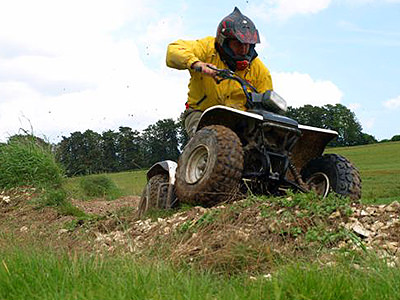 Man driving a quad bike over rough terrain