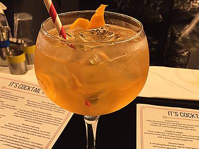 A large Spanish-style stem glass filled with an orange drink