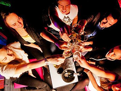 Top-down view of a group of people raising glasses and clinking them together