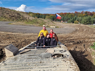 Some of the LNOF team in a tank on a muddy field in Prague