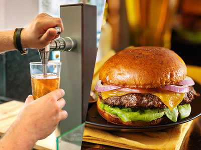 A burger meal with some Doritos and a beer on the side 