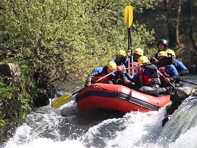 A group of people white water rafting on a river