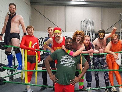A man jumping on another man during a wrestling match