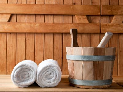 Two towels rolled up with a bucket in a wooden building 