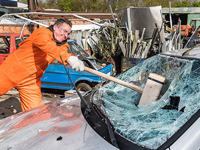 A man smashing a car windshield