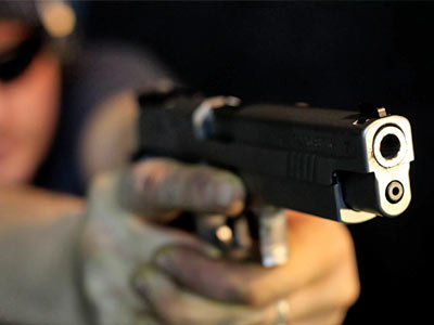 A person's hands on a barrel of a gun
