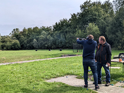 A main aiming at a clay pigeon with a shotgun