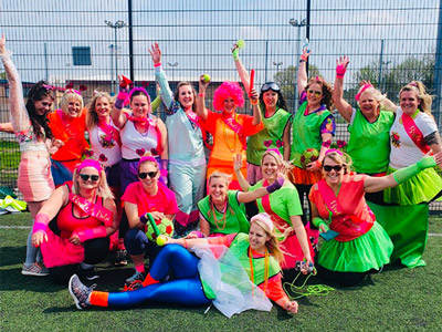 A group of women wearing neon outfits at Olympic Shames