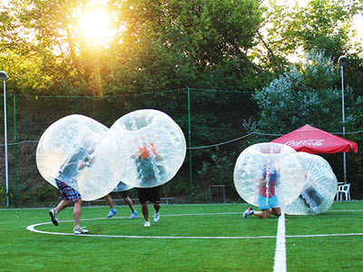 A group of people in inflatable zorbs on a pitch