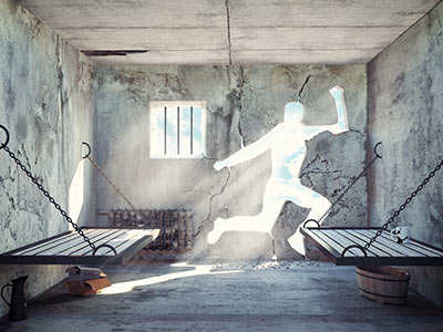 A prison cell room with a cut out of a person in the wall