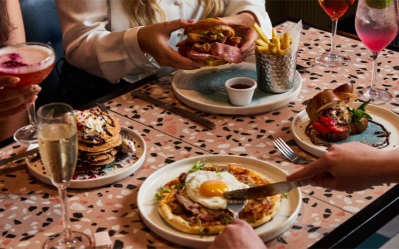 A selection of brunch dishes including pancakes and a burger meal 
