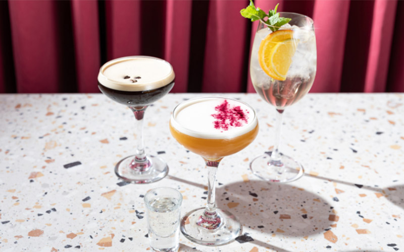 Three cocktails sitting on a table 