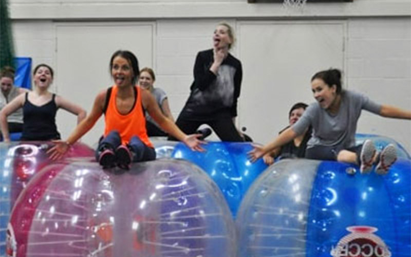 A group photograph of men and women after they've played a game of bubble football
