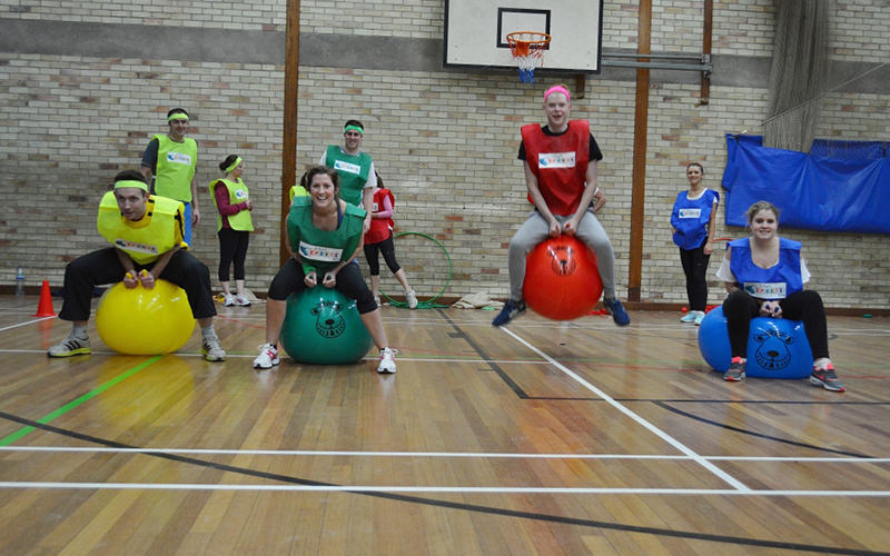  A group of men and woman bouncing on space hoppers