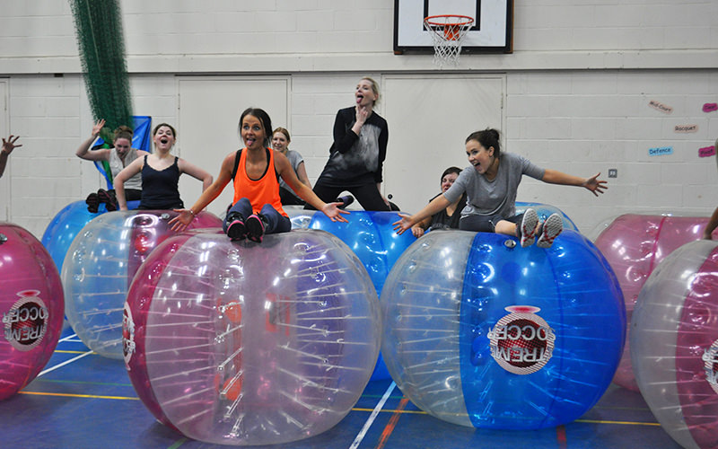 A group of women posing on zorbs