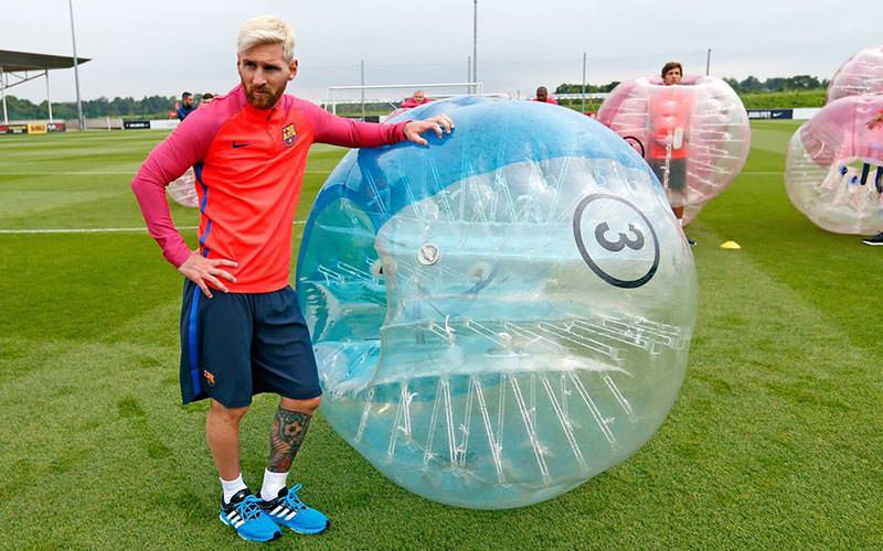 Lionel Messi standing next to a blue inflatable bubble