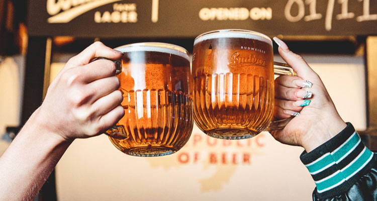 Two people clinking big mugs of beer. 