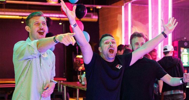 A group of men pointing and celebrating something in Boom Battle Bar in Manchester. 