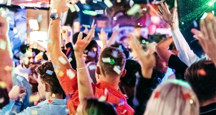 A group of party goers in Walkabout with confetti raining from the ceiling. 
