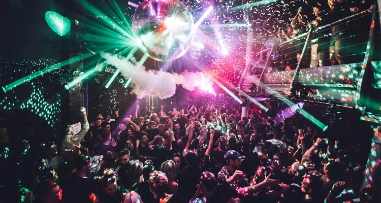 A massive glitterball with a huge crowd partying underneath it. 