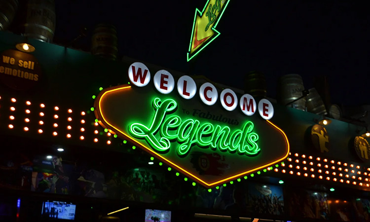 The front of Legends Bar Albufeira with a large Vegas style neon sign reading Welcome Legends 