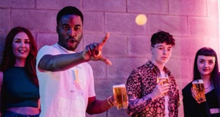 Four people stood with drinks with one of them doing the loser sign with his hand at Boom Battle Bar Bournemouth 