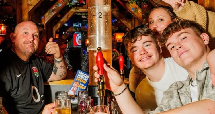 A group of people sat at a table at Barbara's Bier Haus Bournemouth with a big beer tank stood in the middle of the table 