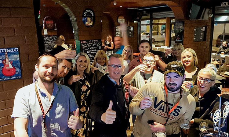 A mixed gender group of people posing for the camera inside Eddy's Bar 