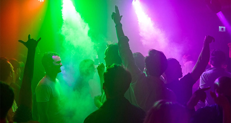Lots of party goers partying under multi-coloured lighting at Poseidon's Club 