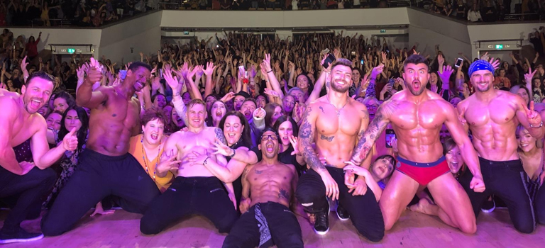 A group of strippers standing on stage in front of an audience