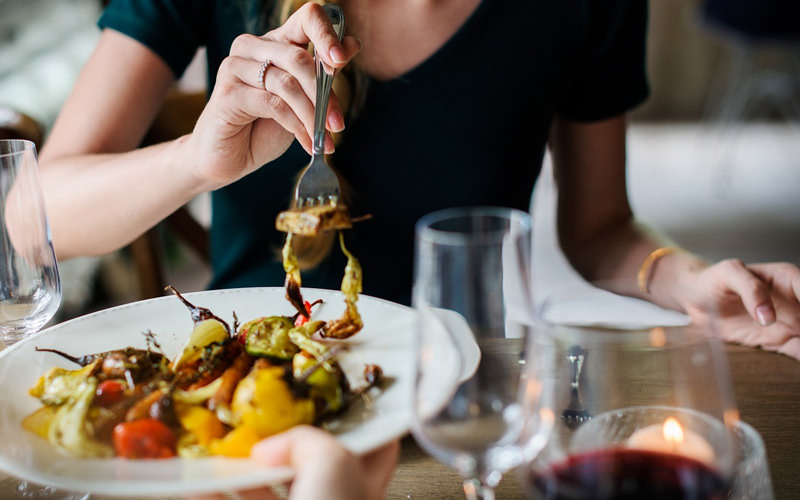 A woman forking some food from a plate