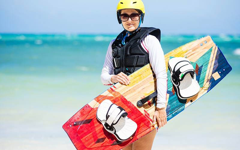 A woman carrying a sandboard