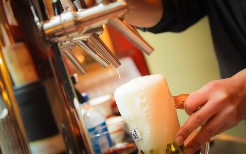 A frothy pint being poured
