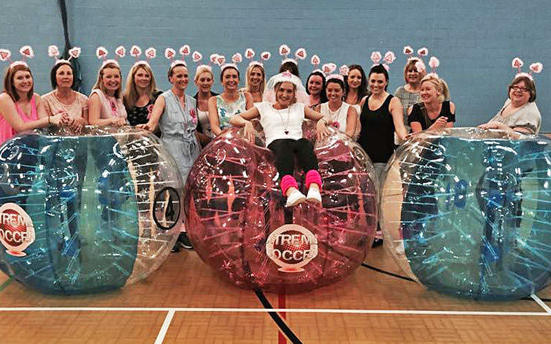 Some women posing with zorbs in bubble mayhen