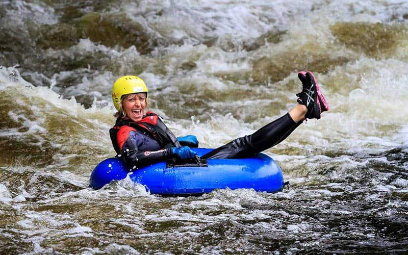 A woman on a rubber ring, floating down the rapids