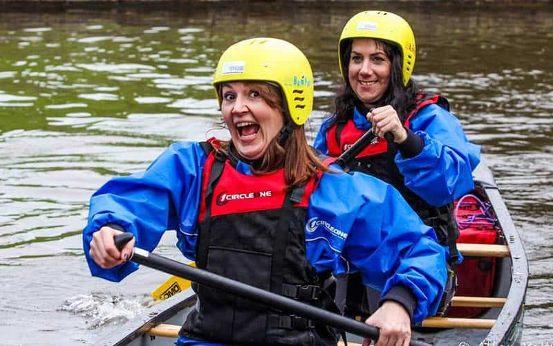 Two happy women rowing a boat