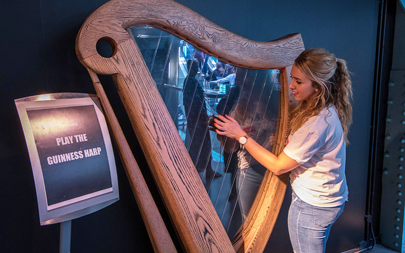 A girl playing the harp in The Guinness Factory, Dublin