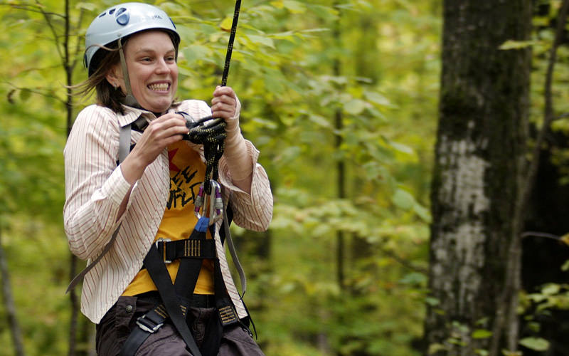 A girl doing a zipwire through the trees