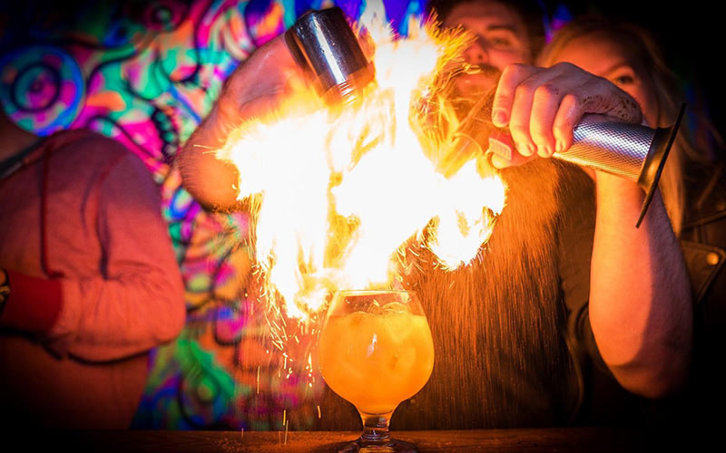 A barman making a flaming cocktail