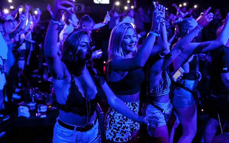 Some girls in Magaluf partying under a blue light